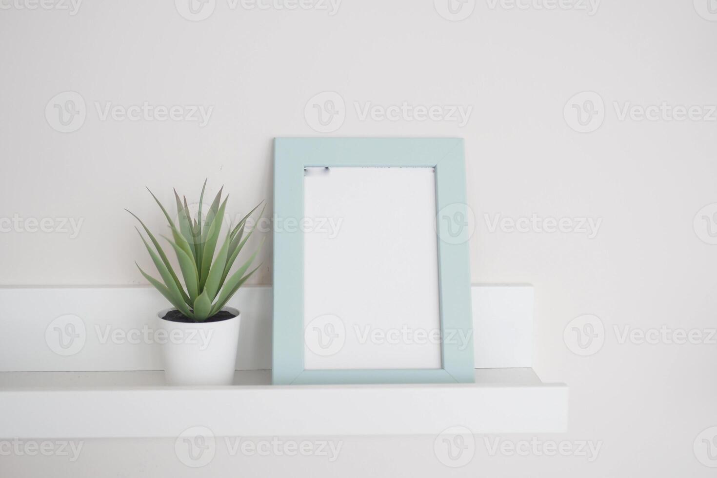 A minimalistic frame with a vibrant plant elegantly placed on a shelf photo