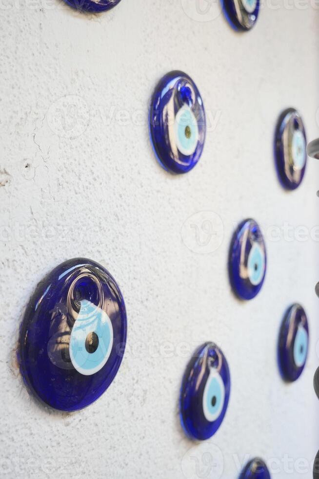 a bunch of blue evil eye keychains hanging on a shelf photo