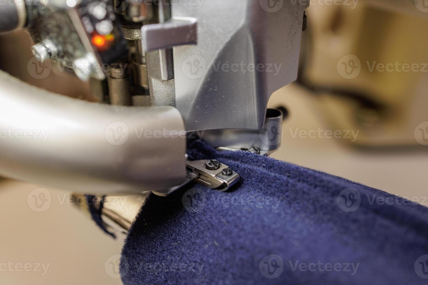 sewing machine overlock close-up in operation, outerwear production photo