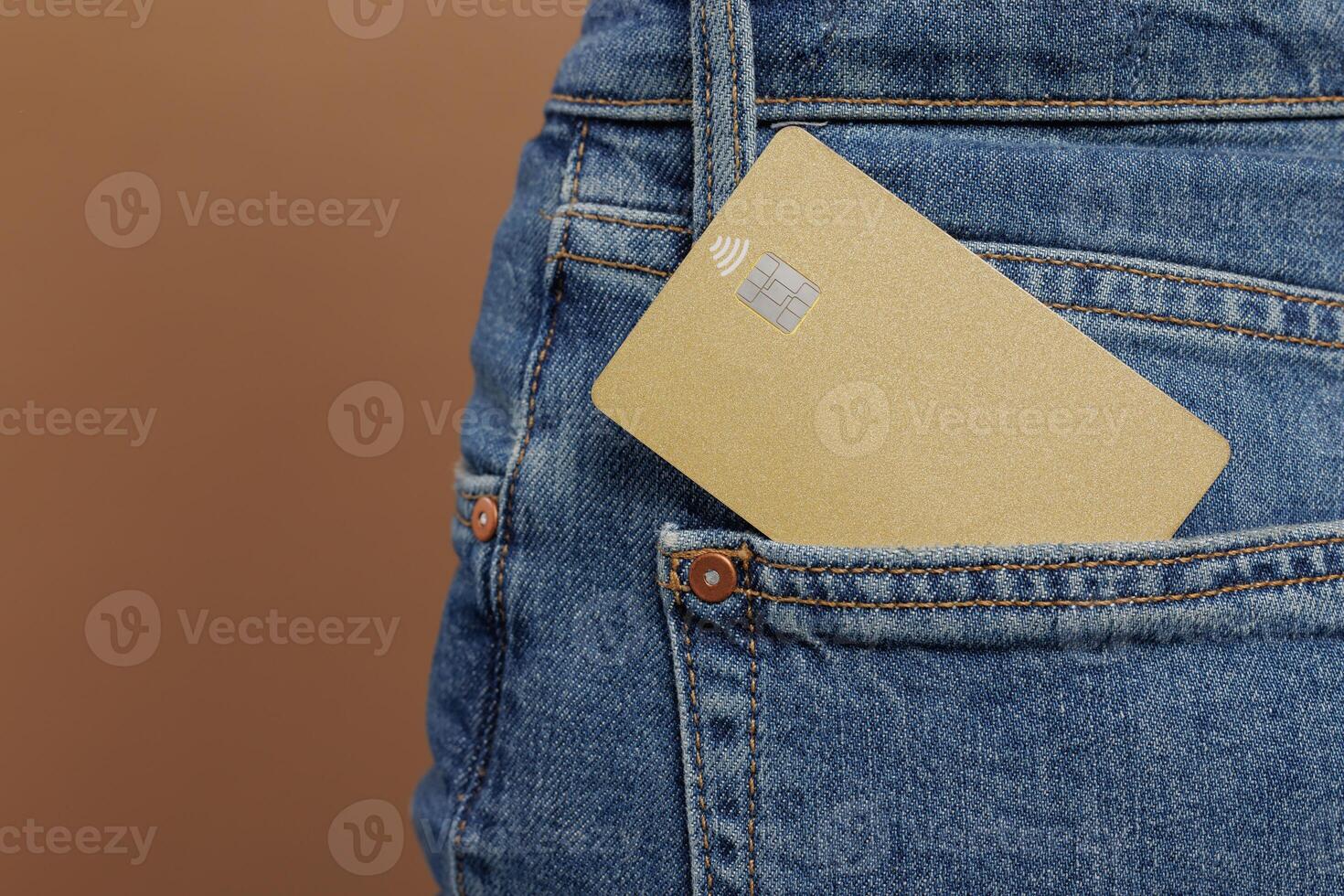 Close up of credit bank card in jeans pocket isolated on beige background photo