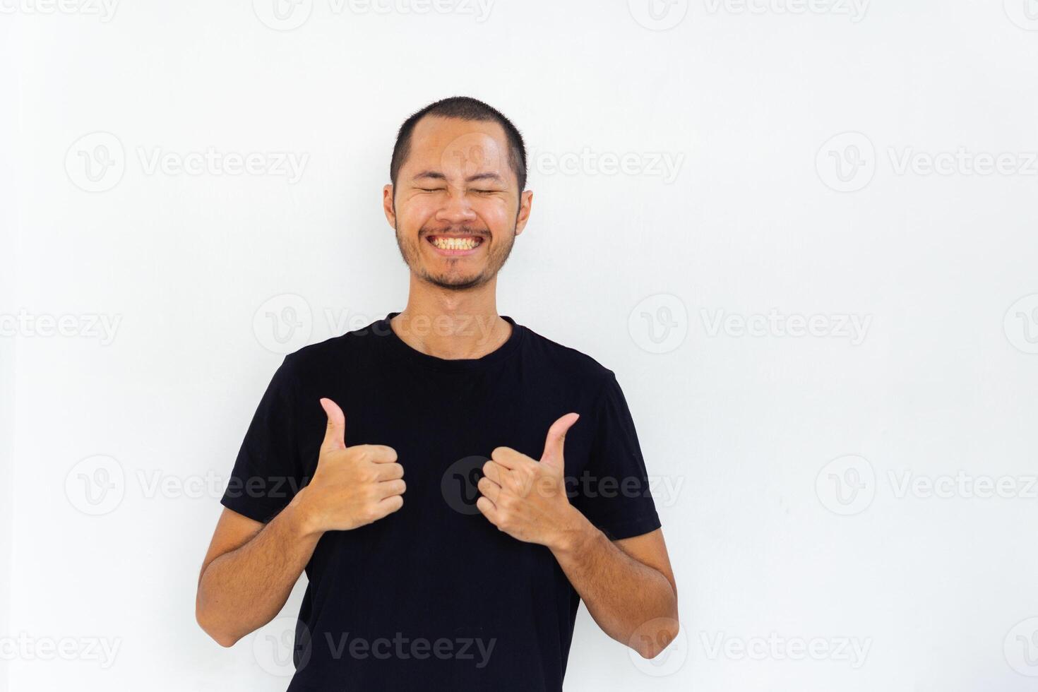Young asian men with black shirt is giving thumbs up with happy expression in isolated white background photo