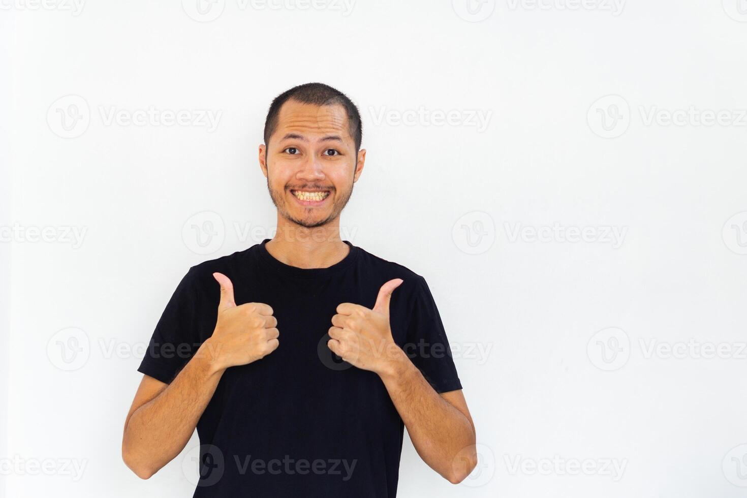 Young asian men with black shirt is giving thumbs up with happy expression in isolated white background photo