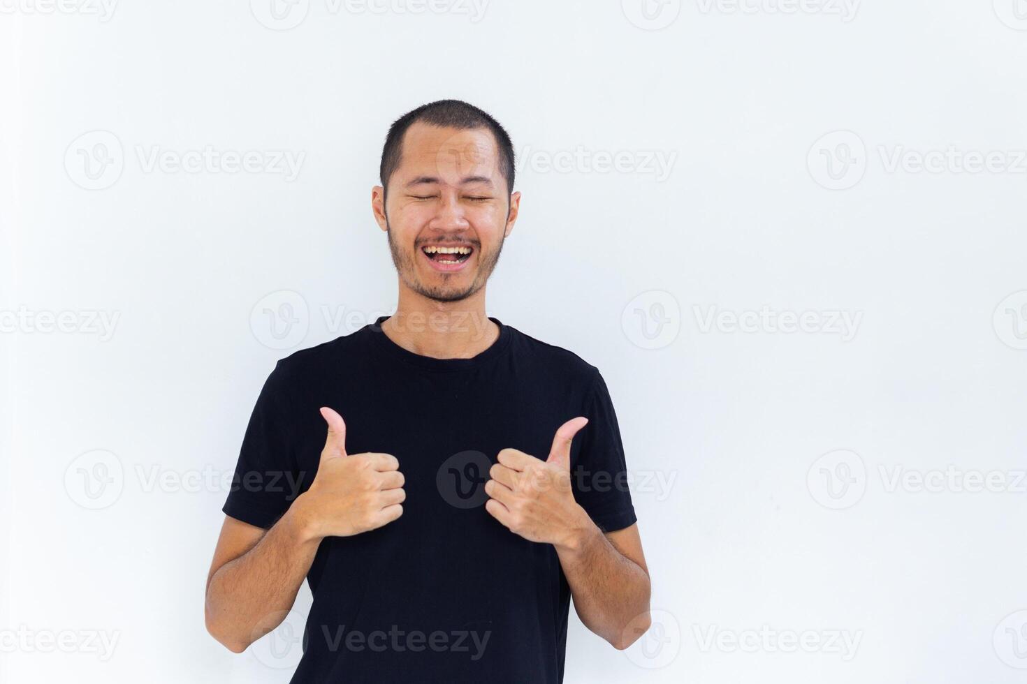 Young asian men with black shirt is giving thumbs up with happy expression in isolated white background photo
