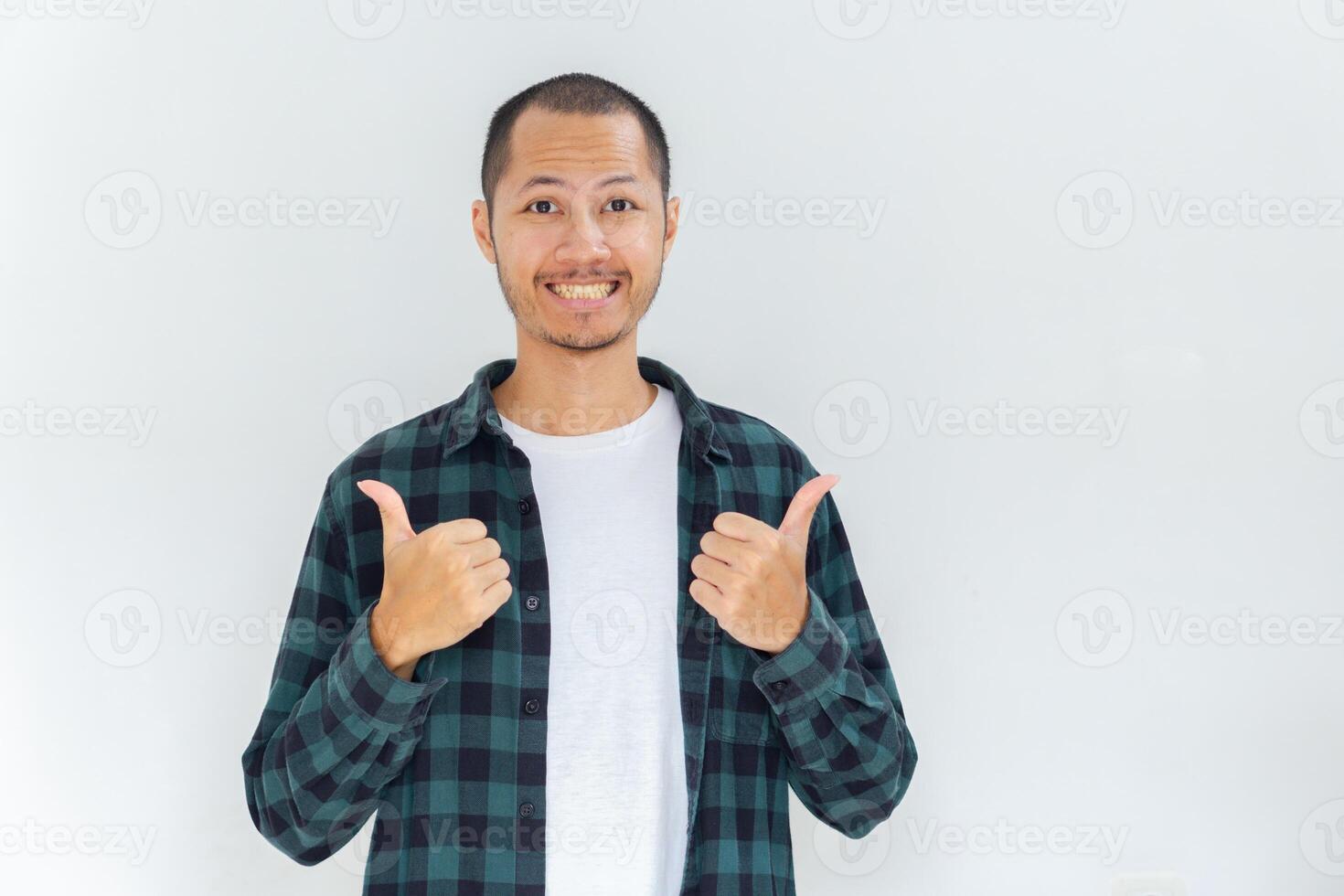 Young asian men with flannel and shirt is giving thumbs up with happy expression in isolated white background photo