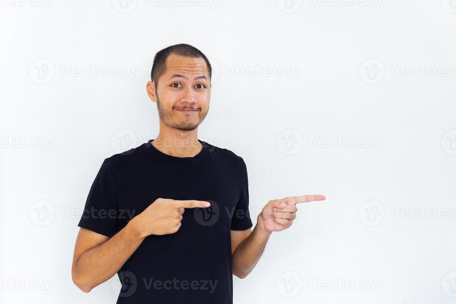Young Adult Asian men wearing black shirt pointing finger to the right with smiling face and exited expression with isolated white background photo