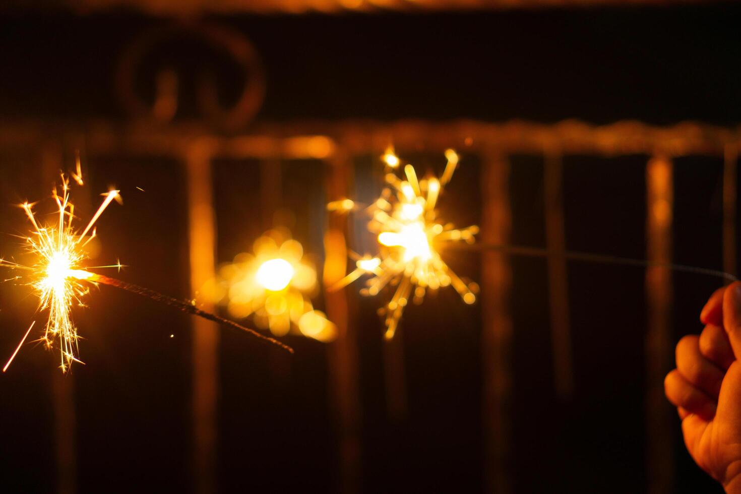 Playing firework sparkles in night with silhouette of hand of kids for new year event photo