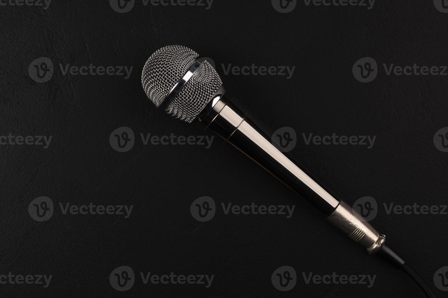 Black and silver microphones in the studio on a black and dark background. Professional recording equipment. Top view. photo