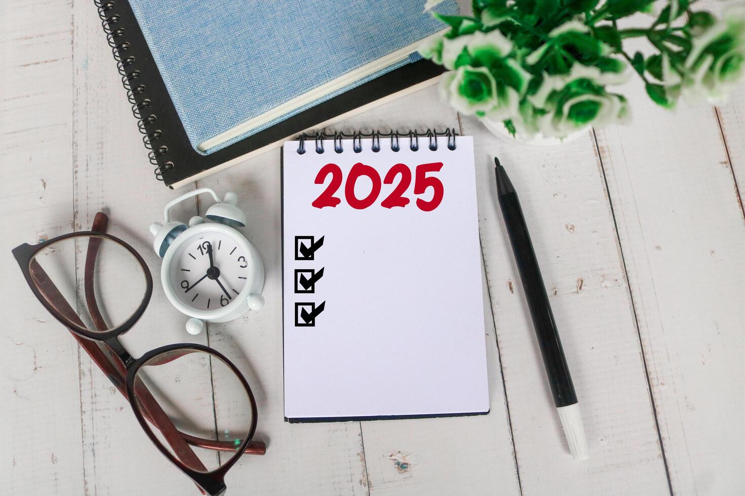 2025 New Year resolutions goals, plans, and resolutions concept. Planning checklist 2025 target on notebook with office desk background photo