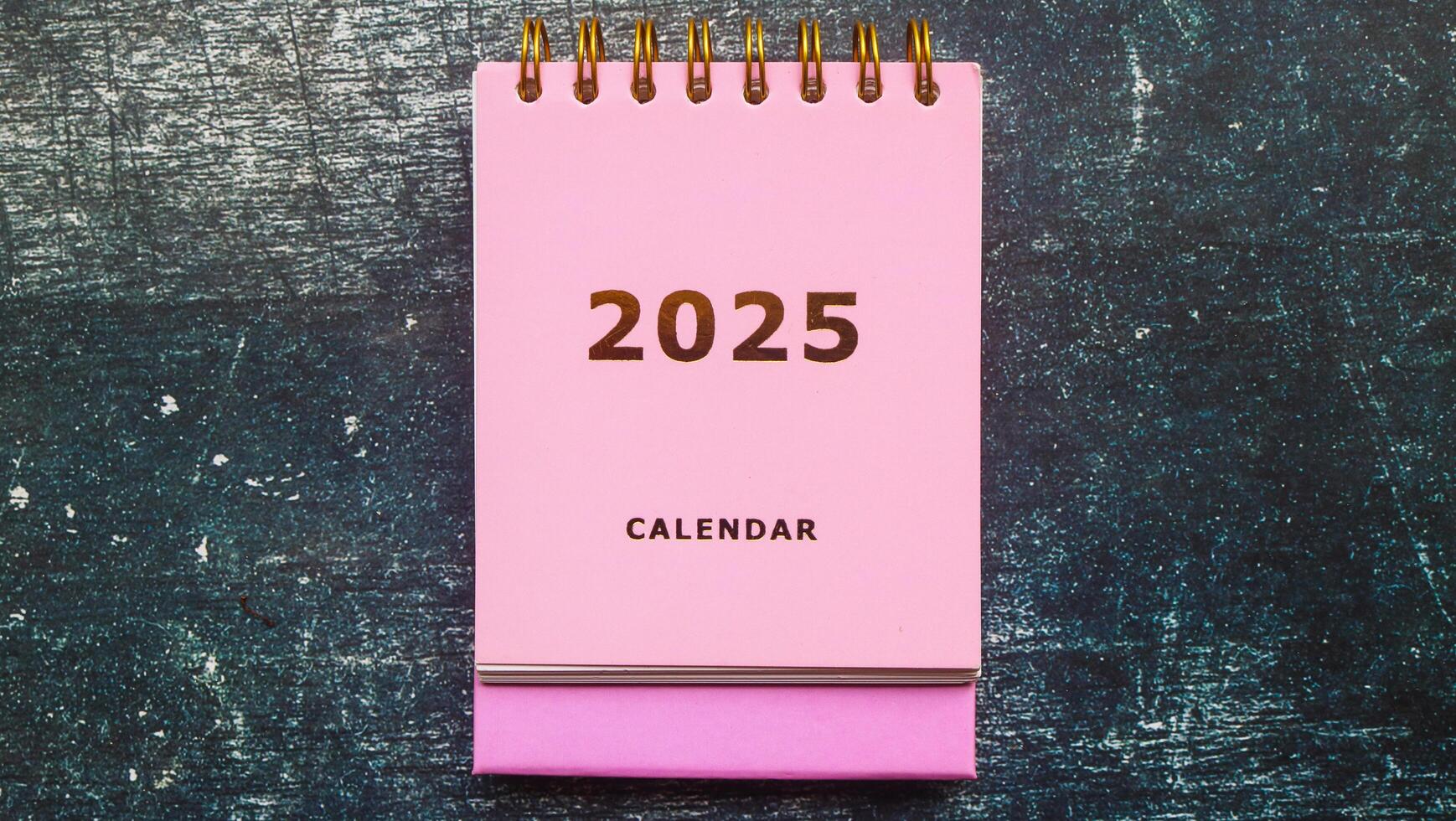 2025 calendar pink isolated on table. Calendar and Note Pad Happy New year 2025. 2025 New Year resolutions goal, plan, and action concept photo