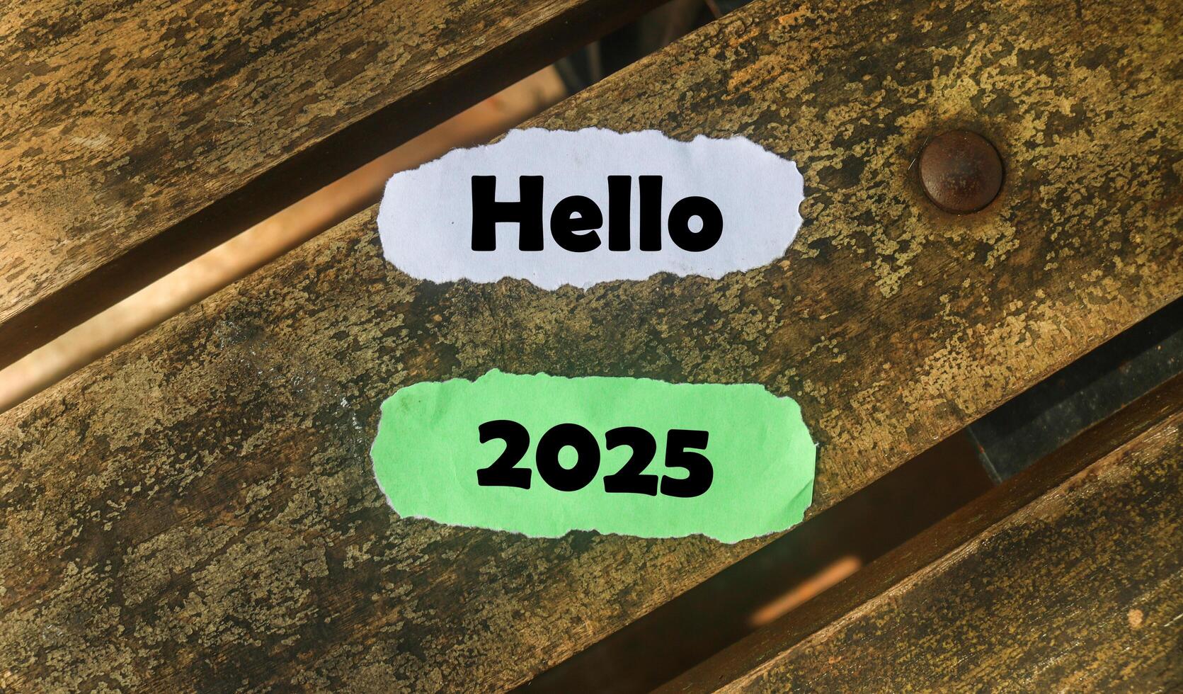 Hello 2025 on torn paper on wooden table. New year concept with typographic Hello 2025 on paper. photo
