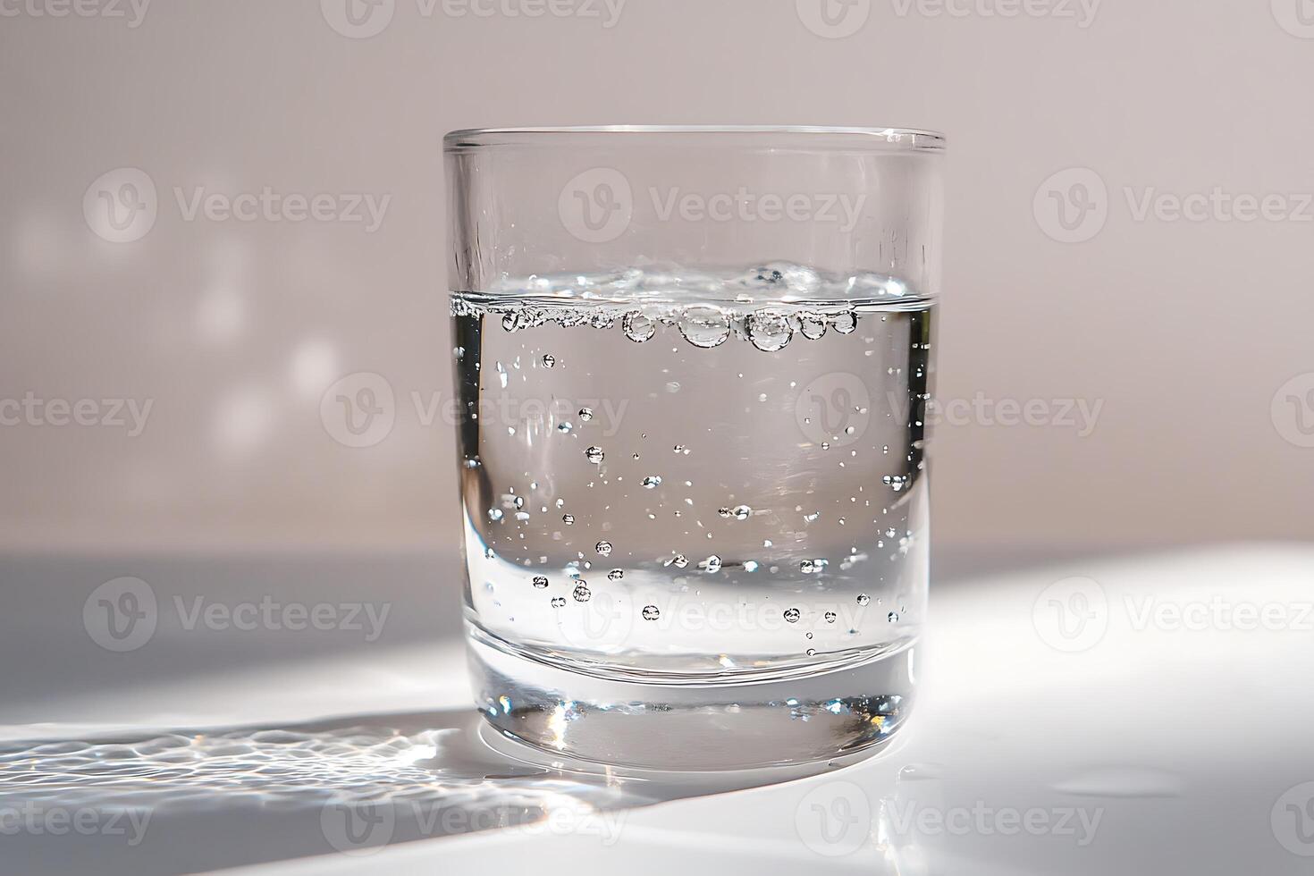 A glass of water with bubbles on the surface photo