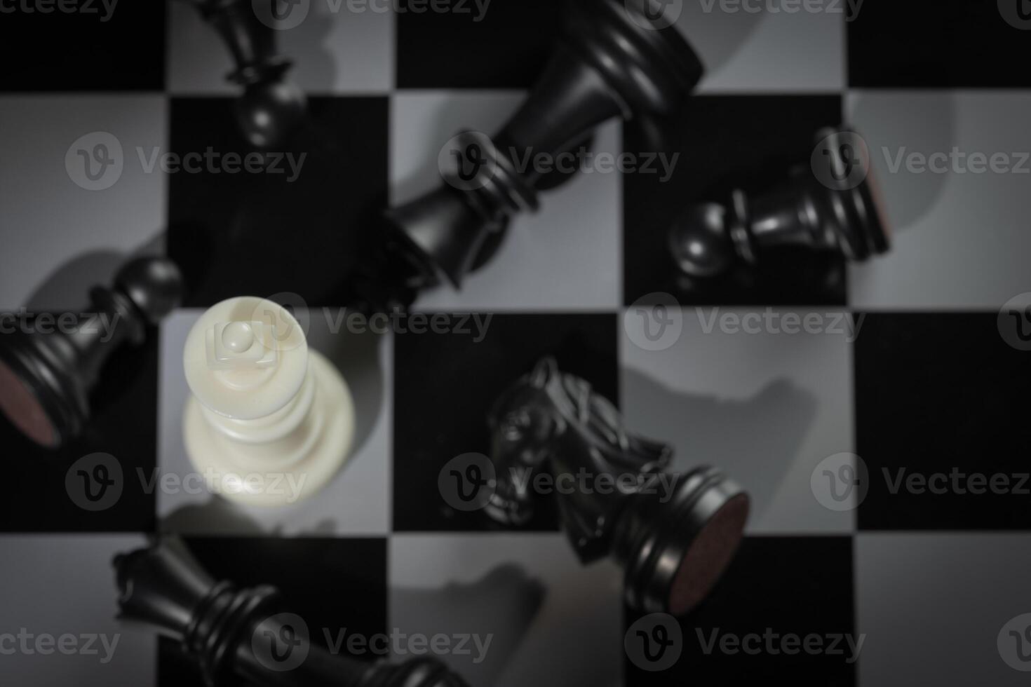 A close-up of a chessboard highlighting the white KING standing out among black pieces, symbolizing strategic thinking, leadership, and decisive planning in overcoming challenges and achieving goals. photo