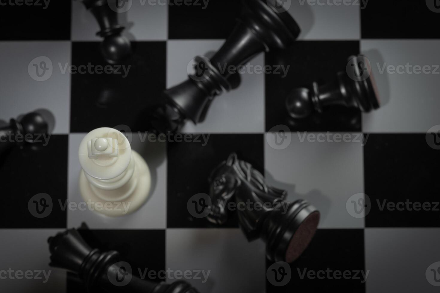A close-up of a chessboard highlighting the white KING standing out among black pieces, symbolizing strategic thinking, leadership, and decisive planning in overcoming challenges and achieving goals. photo