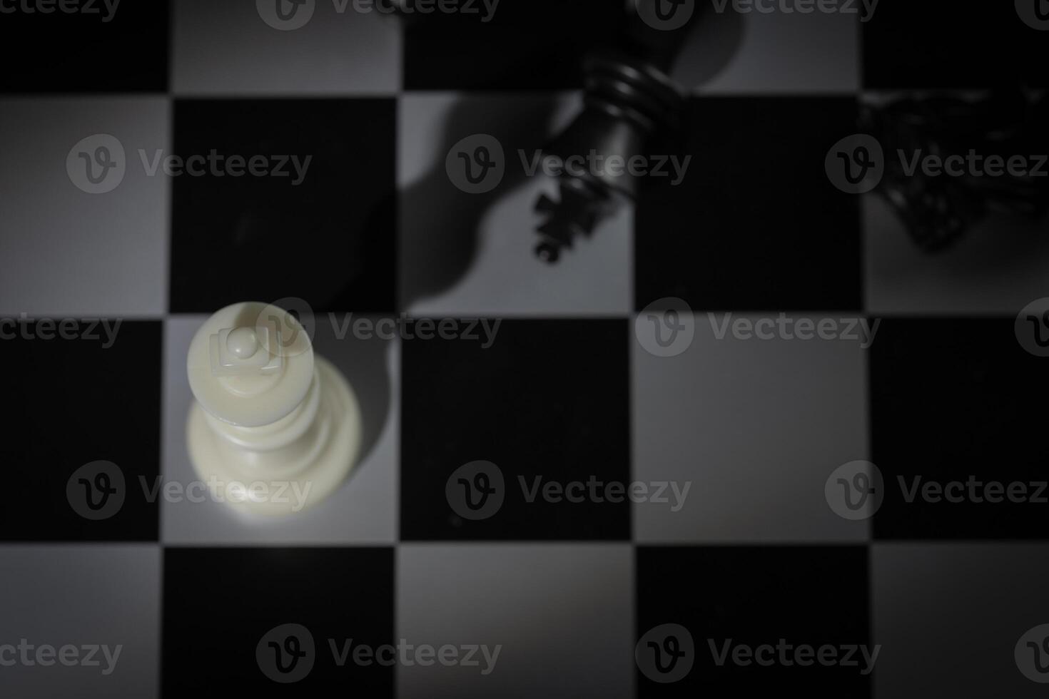 A close-up of a chessboard highlighting the white KING standing out among black pieces, symbolizing strategic thinking, leadership, and decisive planning in overcoming challenges and achieving goals. photo