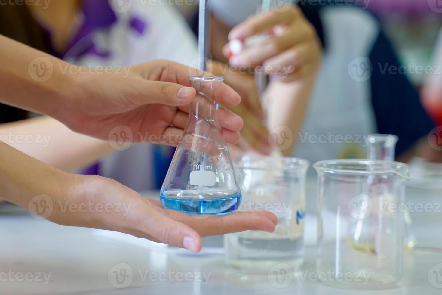 Close-up of a student performing an acid-base titration experiment. Concept of chemistry lab, science, experiment, skills, learning. photo