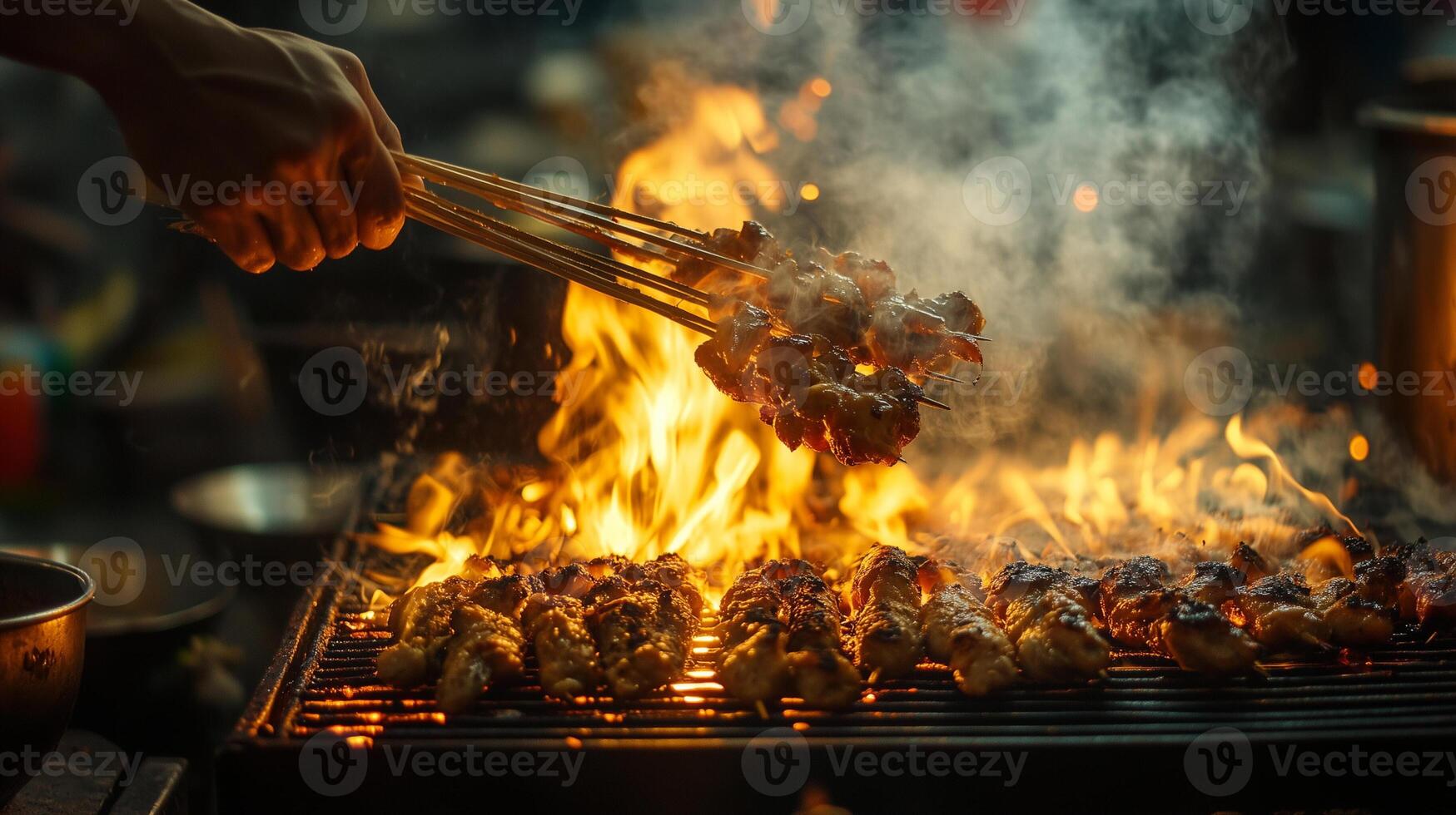 grilling chicken satay in open flame, indonesia street food photo