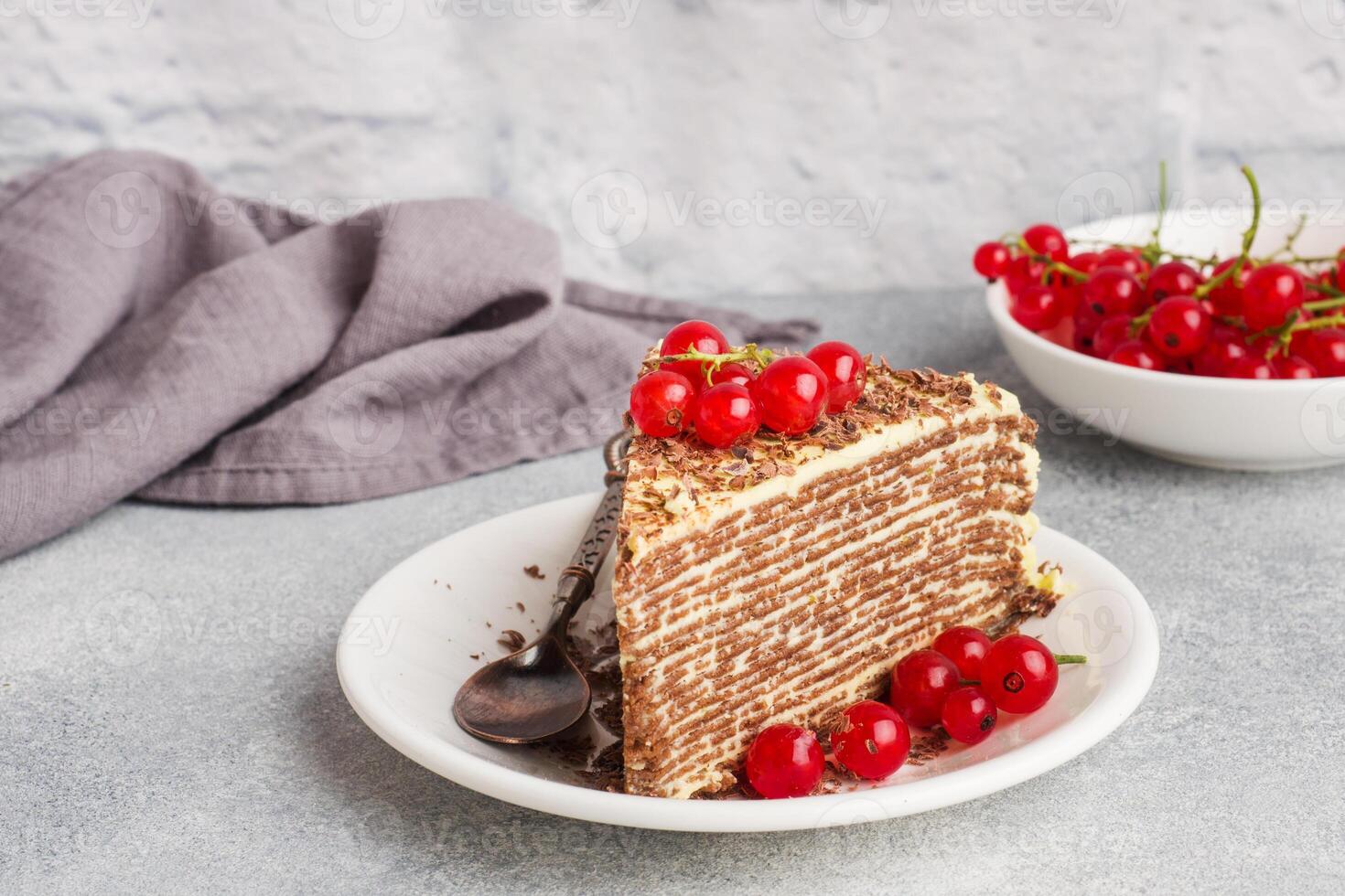 Delicious cake layers of thin pancakes and buttercream, ripe currant berries photo