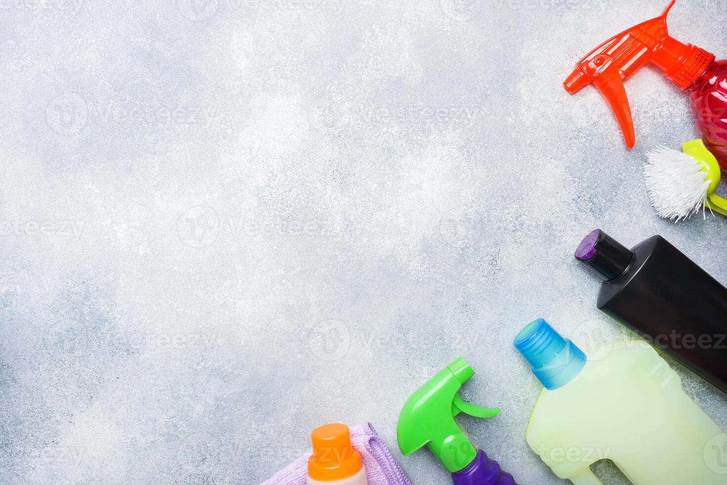 Bottles with detergents, brushes and sponge on wooden background. cleaning concept. photo