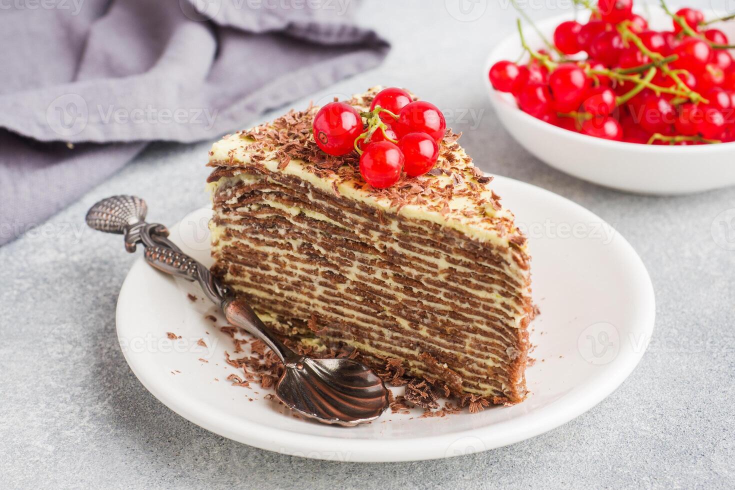 A piece of pancake cake with currant berries photo