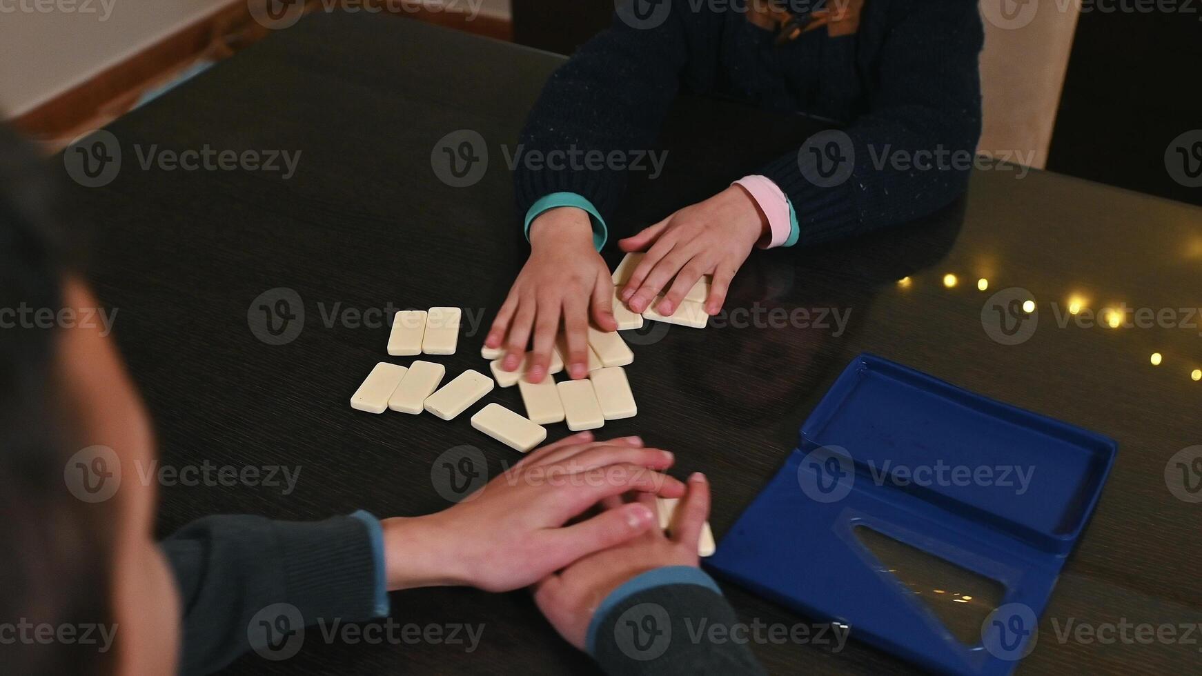 Children Playing a Tabletop Game Together at a Wooden Table photo