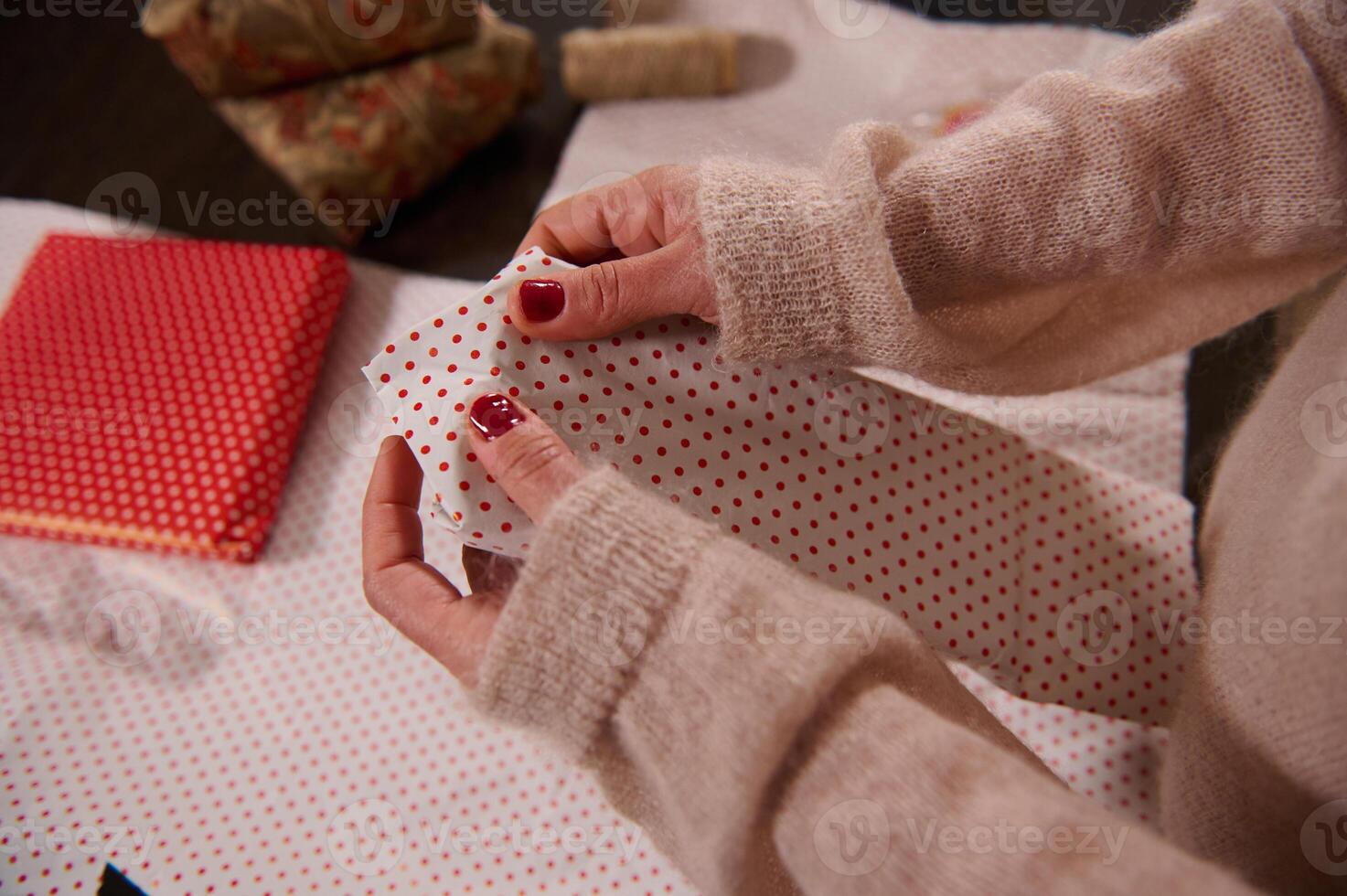 Hands folding polka dot wrapping paper for creative gift wrapping photo