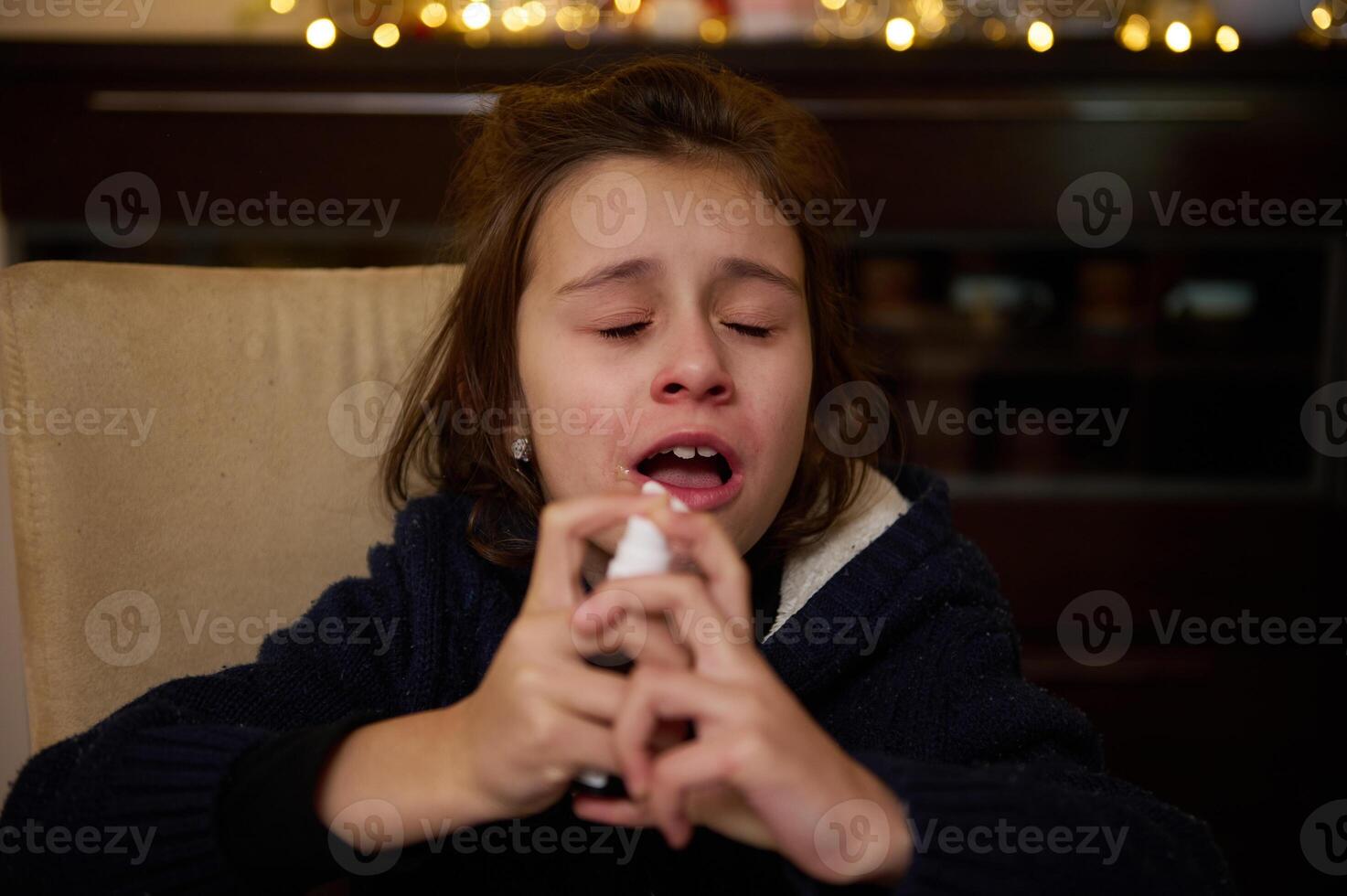 Child using nasal spray during winter holiday season indoors photo
