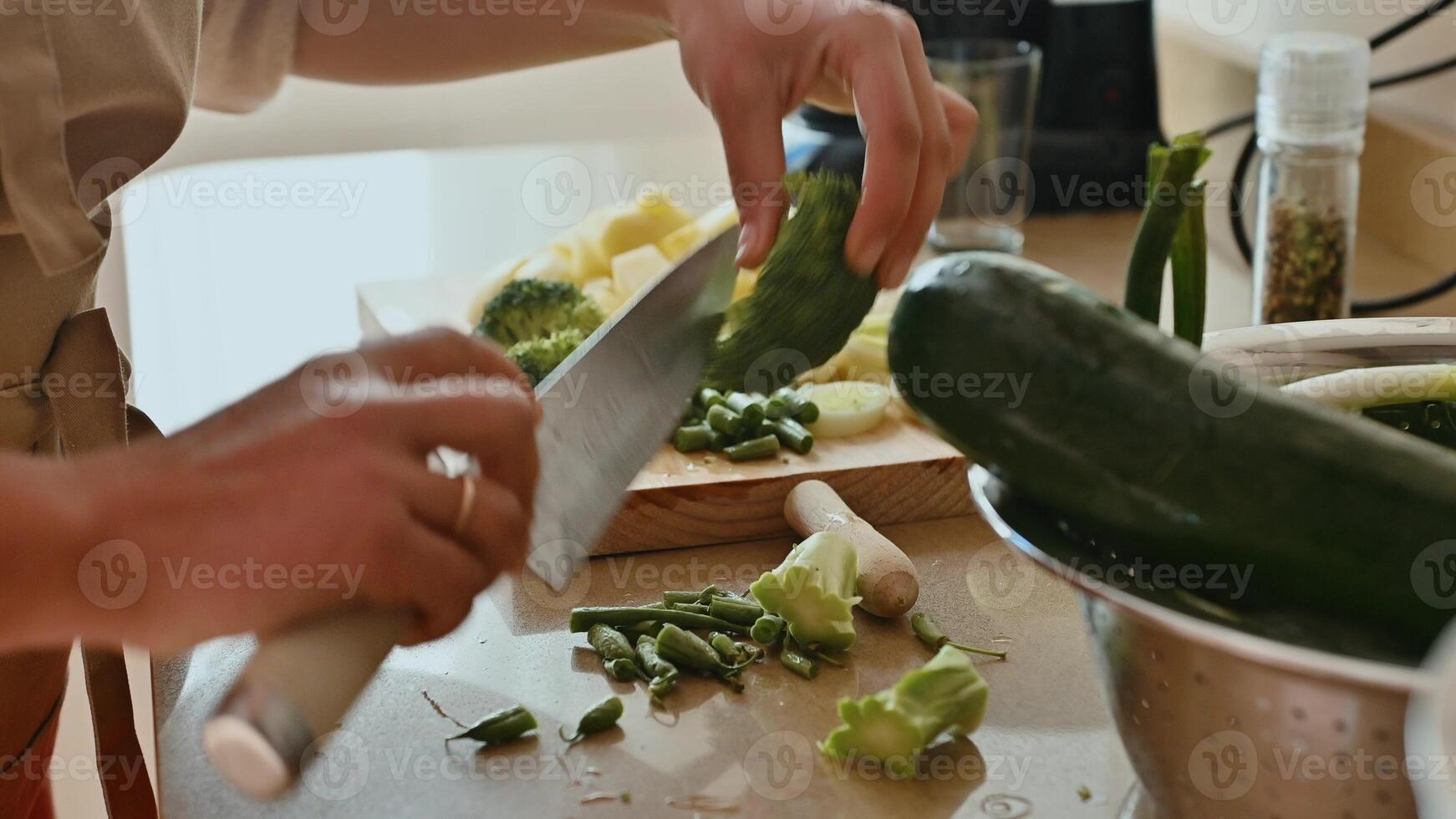 Person preparing vegetables in the kitchen for healthy meal preparation photo