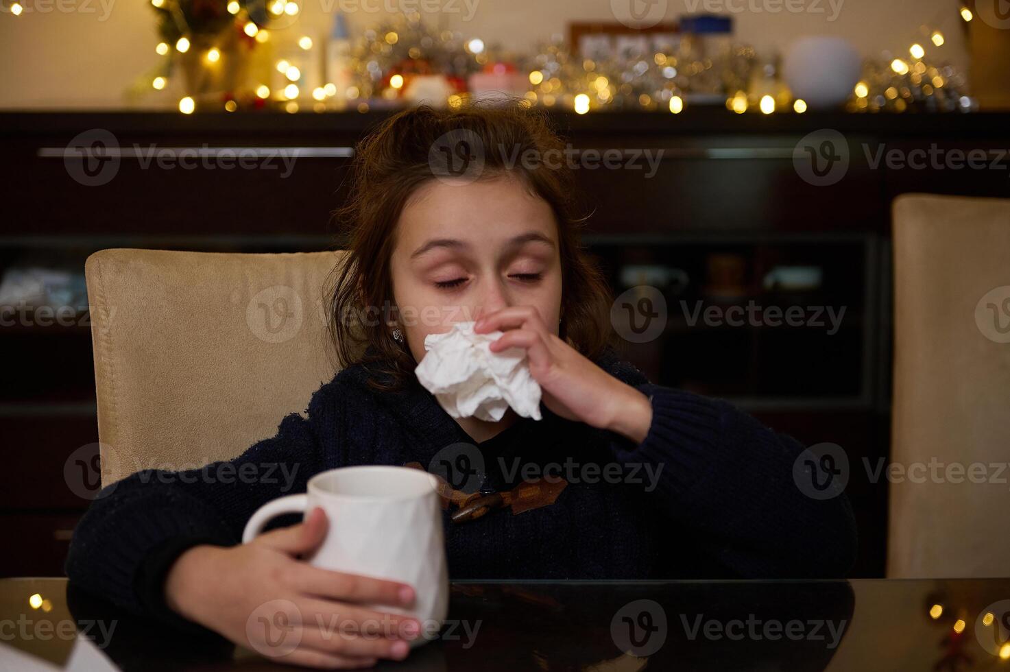 Young girl with a cold drinking tea during the festive season photo