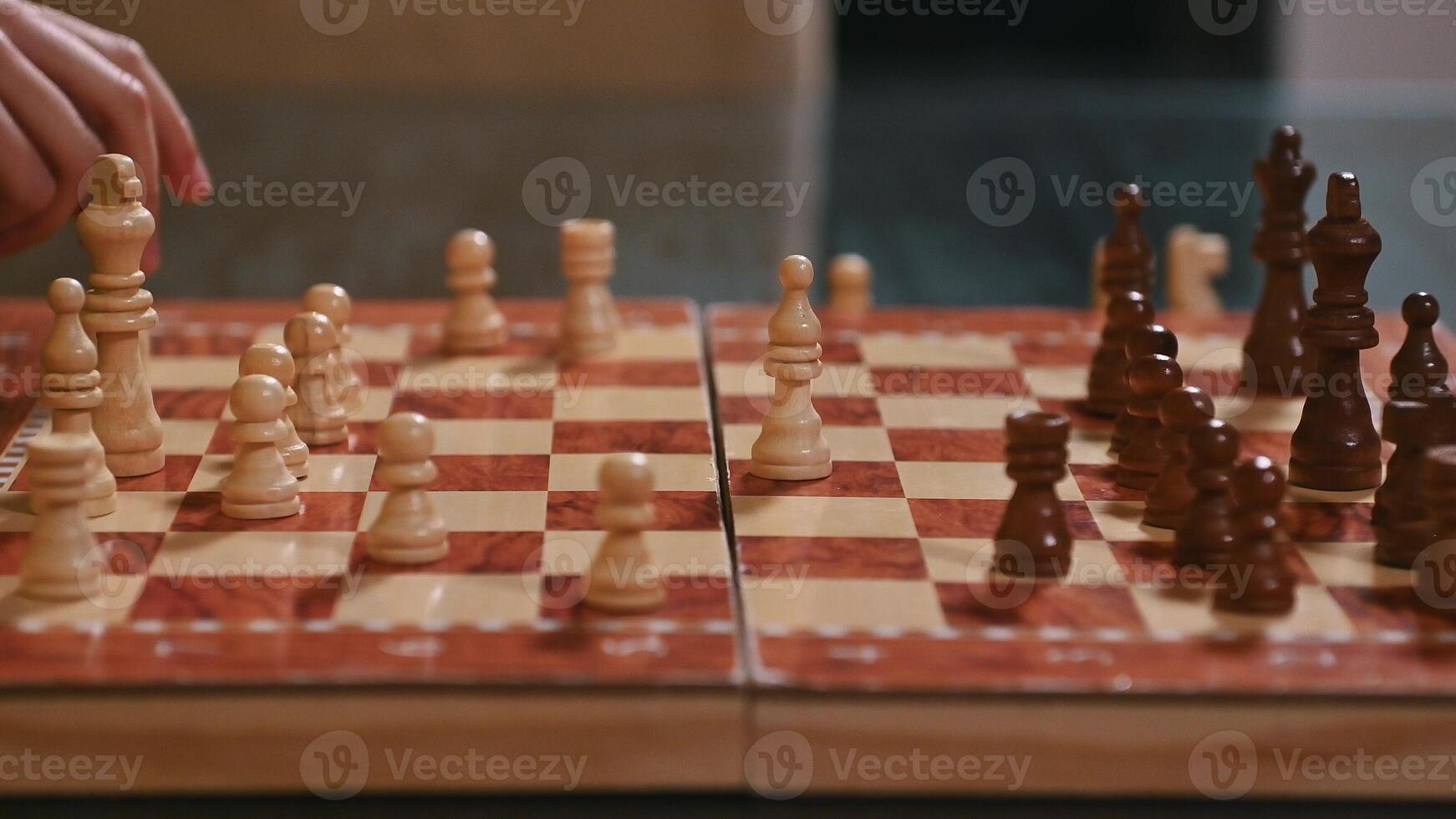 Close-up of a chess game mid-play on a wooden chessboard photo