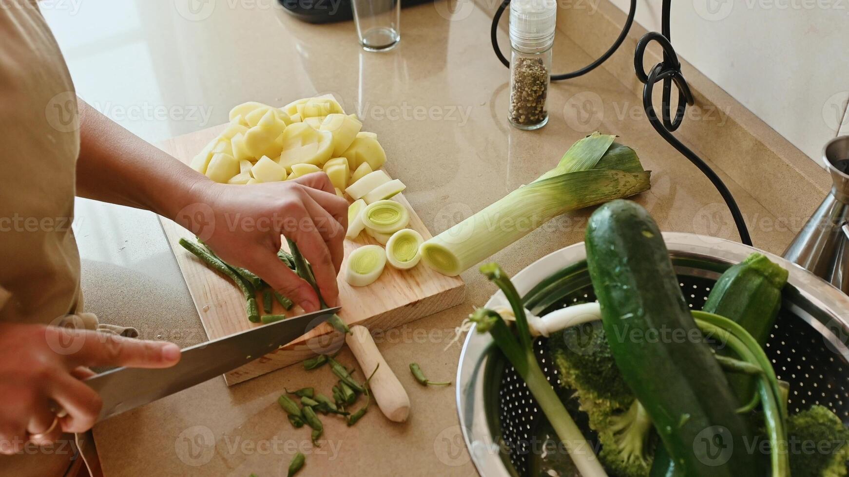 Person chopping vegetables in a kitchen with fresh ingredients for cooking photo