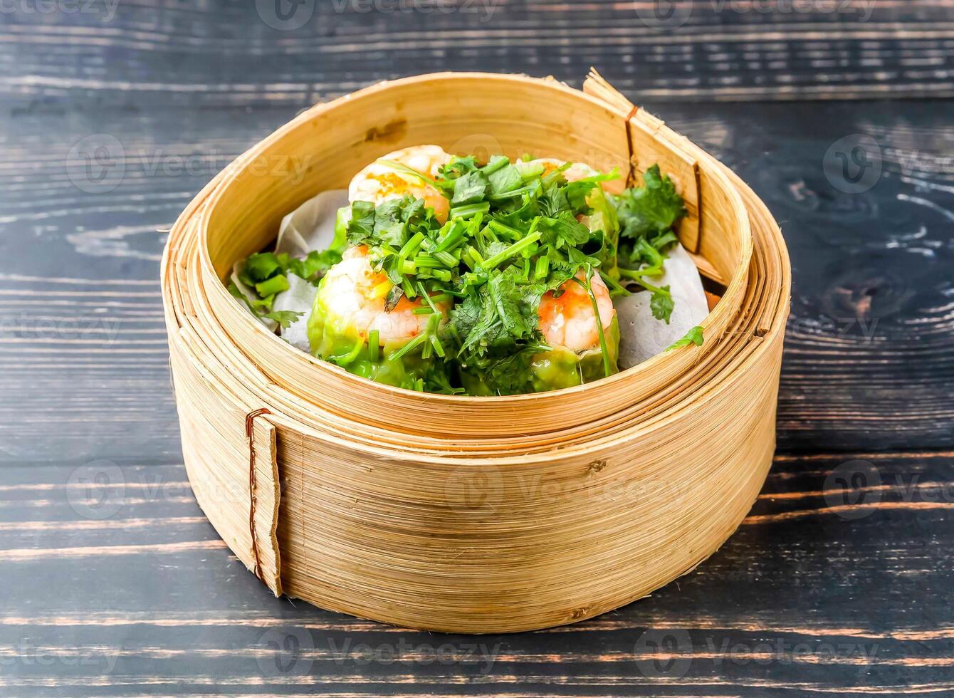 coriander siomai served in bamboo steamer isolated on wooden table side view of hong kong food photo