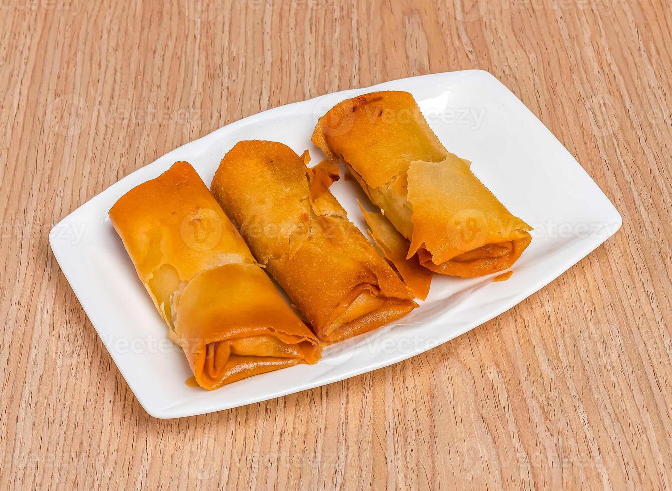 Fried Garlic Shrimp Spring Rolls served in tray dish isolated on wooden table side view of hong kong food photo