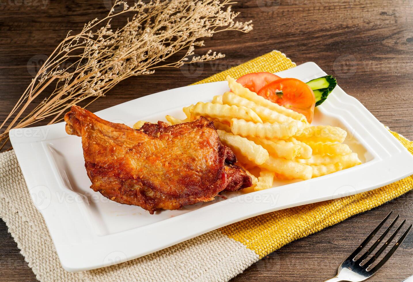 Fried chicken with French fries and salad served on tray dish isolated on napkin side view of hong kong food on wooden table photo