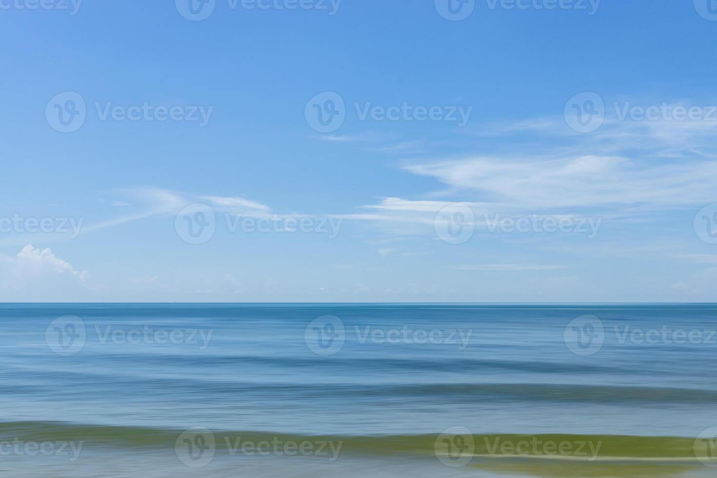 Motion of the wave on the beach with blue sky and clouds. photo