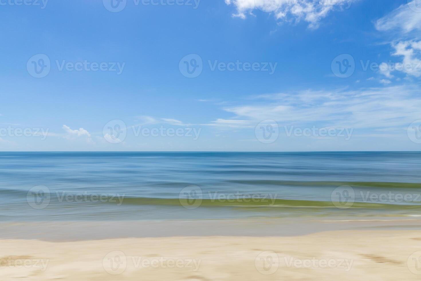 Motion of the wave on the beach with blue sky and clouds. photo
