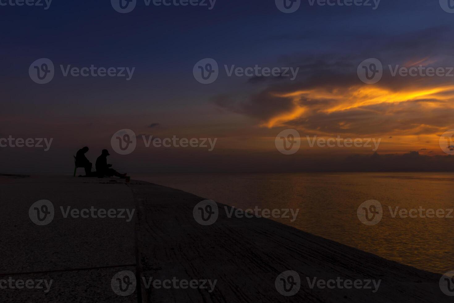 silhouette of fishermen at the lake with twilight sky. photo
