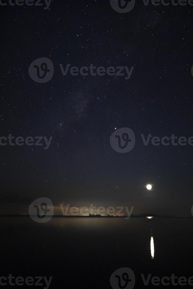 Vertical image of Stardust in the night with noise and grain on the sky with soft light of city in bottom photo