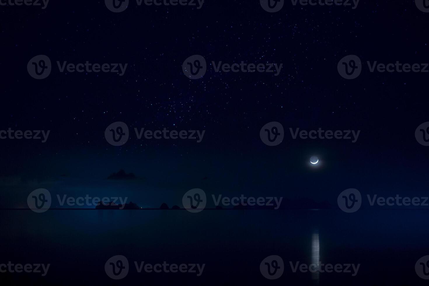 The sky with star and moon is above on mountain at the lake in blue night. photo