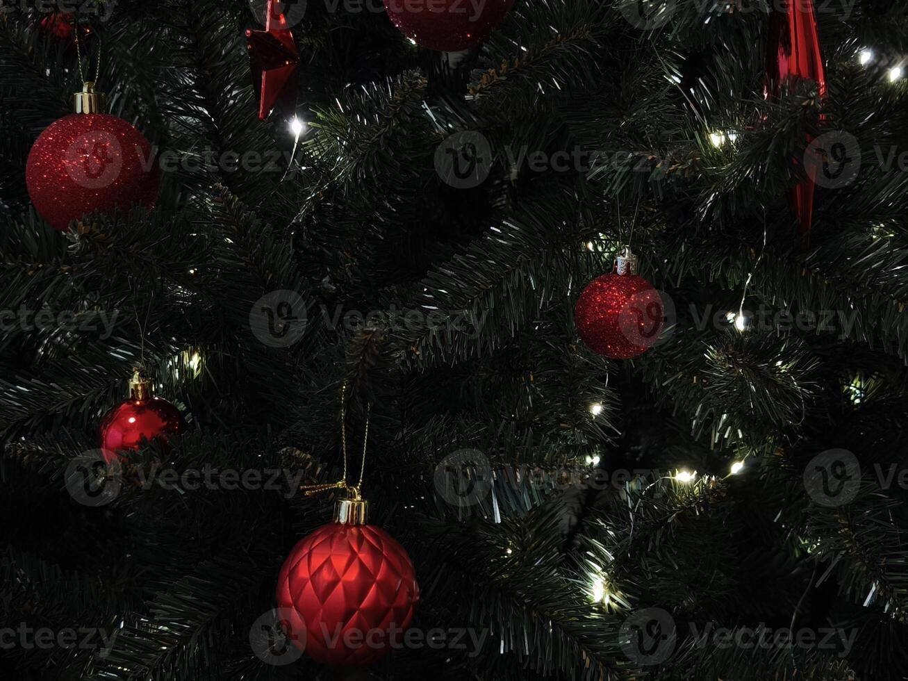 Christmas tree decorated with red ornaments and glowing lights in prague New Year preparation decor photo