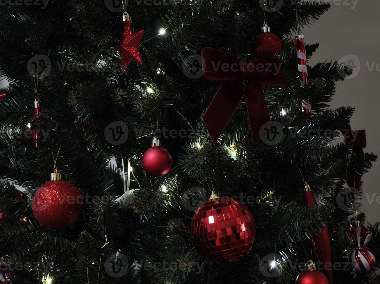 Christmas tree decorated with red ornaments, bow, and candy canes New Year preparation decor photo