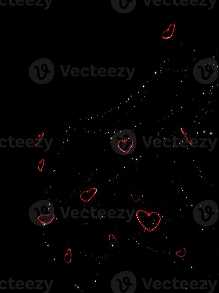 Red heart shaped lights shining in the night sky in prague Valentines day copy space photo