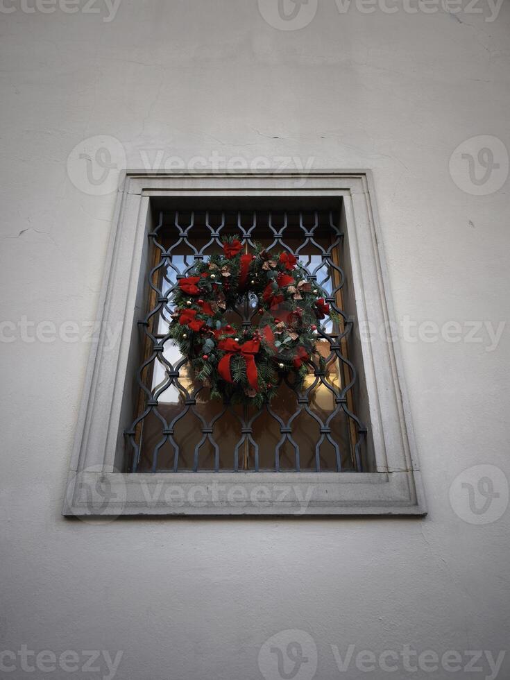 Christmas wreath hanging on a window with metal grille in prague castle photo