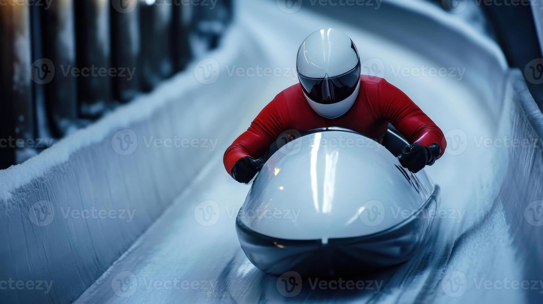 Professional athlete is sliding down the ice track on a luge during a race photo