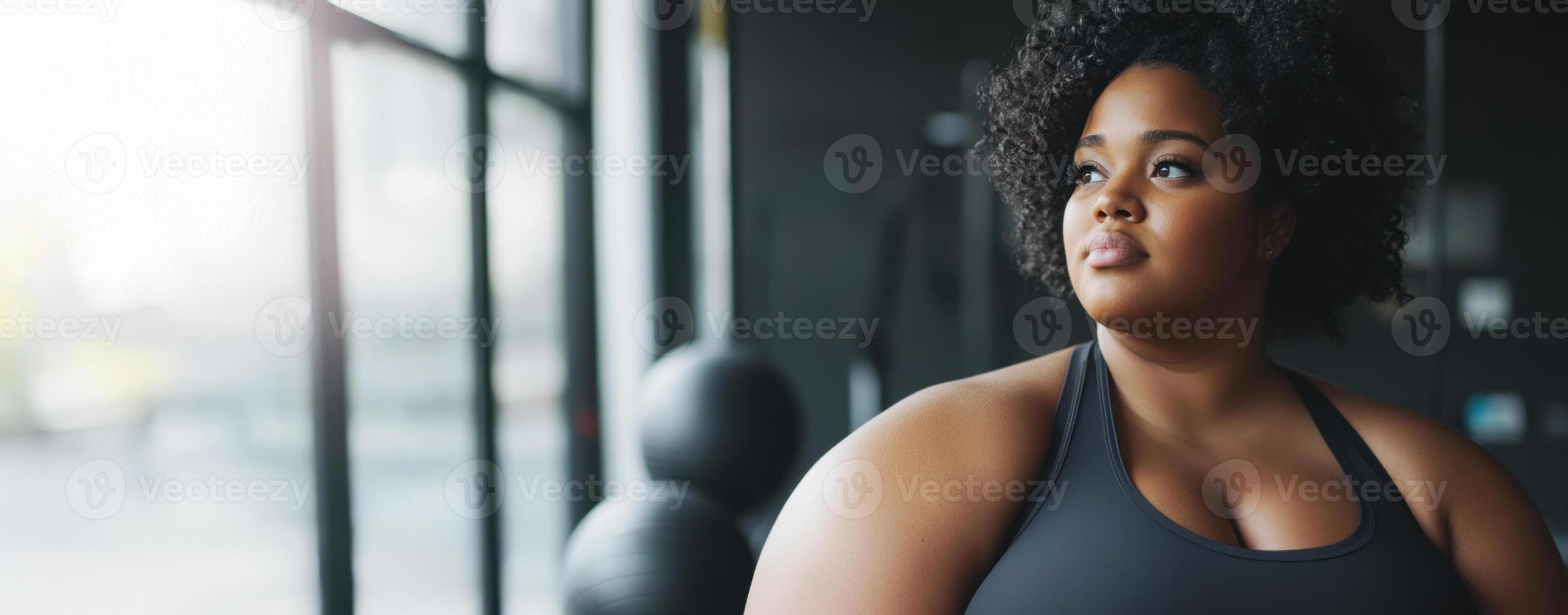 Plus size woman taking a break contemplating in a gym photo