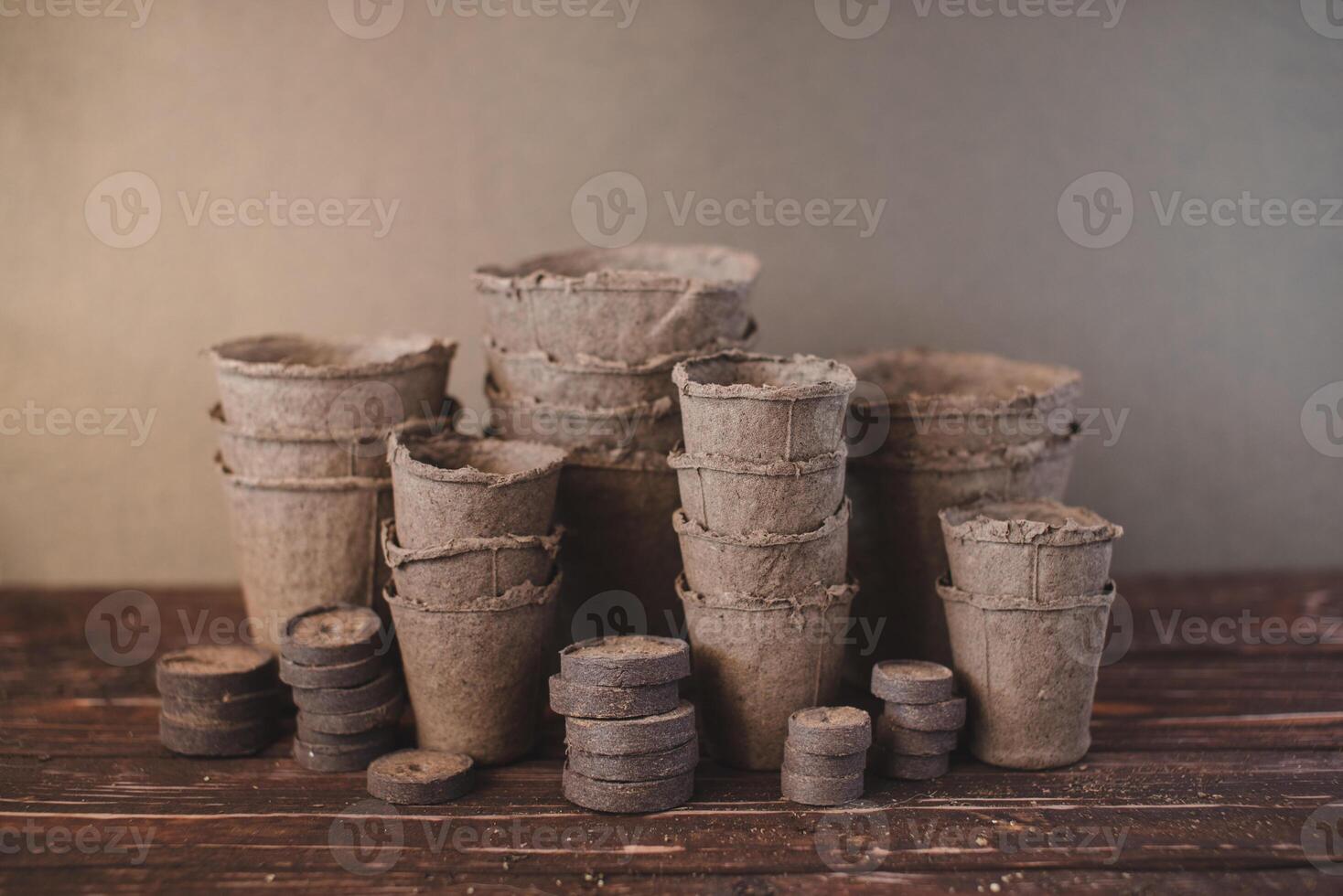 Peat tablets and peat pots for growing seedlings on a wooden background. Eco-friendly. photo