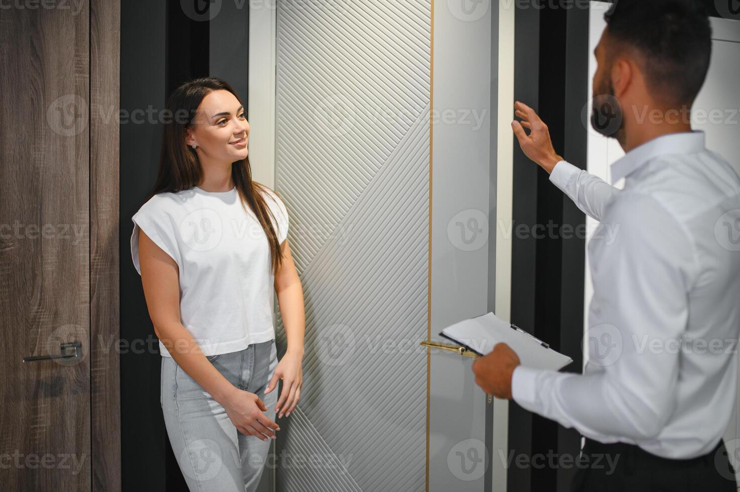 Portrait of smiling young woman shopping in the hardware store choosing different door options photo