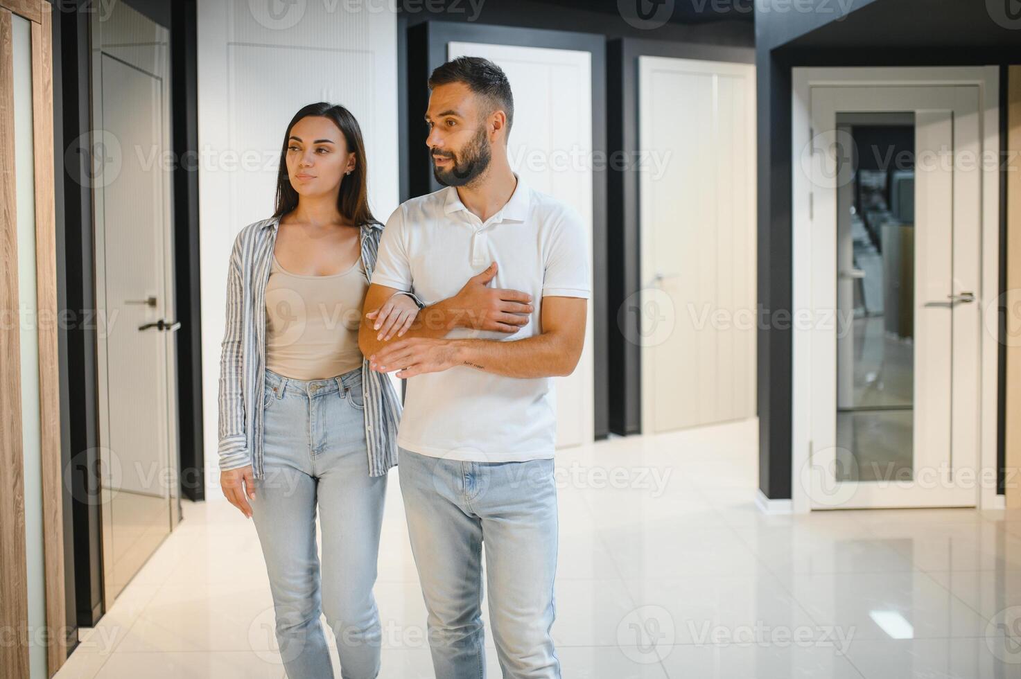 Portrait of smiling young man and woman shopping in the hardware store choosing different door options photo