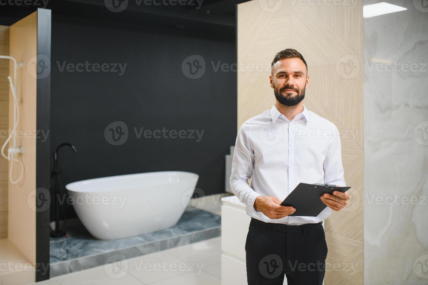 Happy salesman plumber man with paper tablet on plumbing shop photo