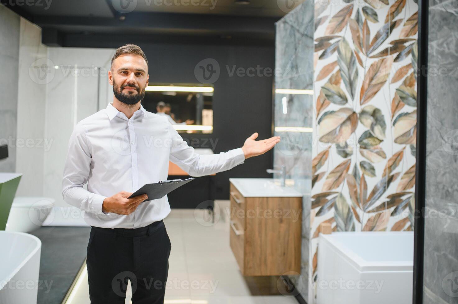 Happy salesman plumber man with paper tablet on plumbing shop photo