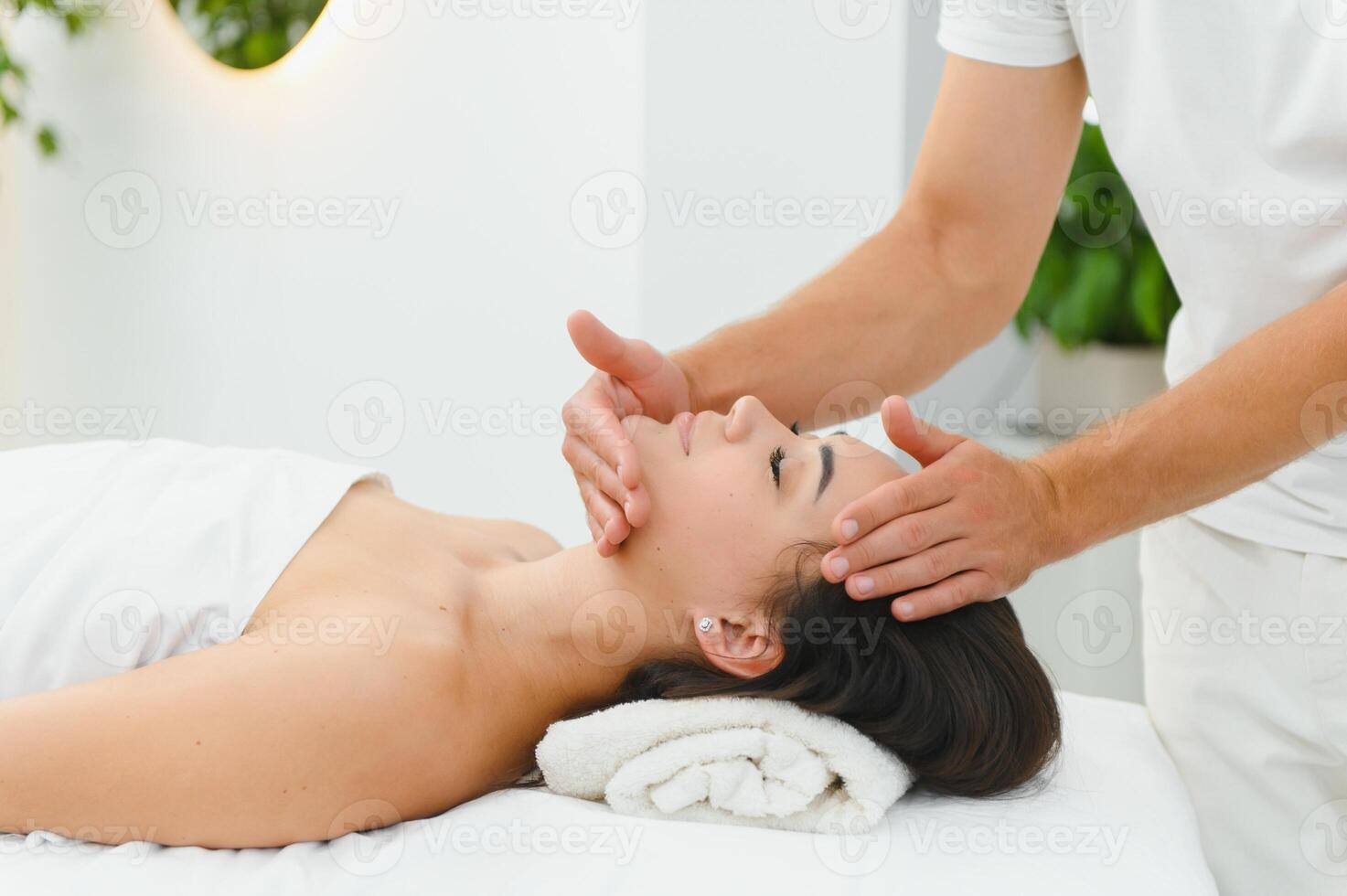 Theres no better way to relax. Shot of an attractive woman enjoying a face massage photo